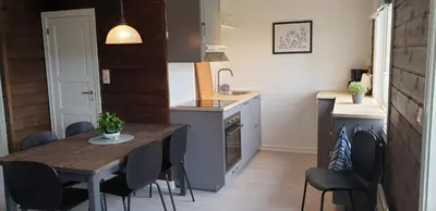 a kitchen with a wooden table and chairs in a room at Oppdal Alpintun Stølen ski in - ski out in Oppdal