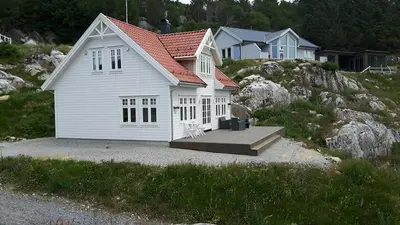 a small white house with a red roof at Havbris in Bremnes