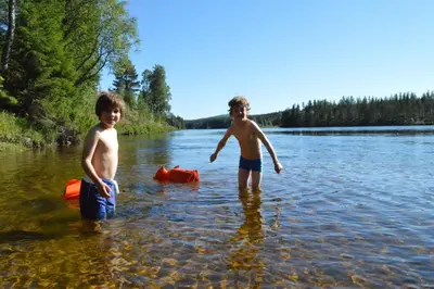 two young boys standing in the water in a lake at Trysil Hyttegrend in Trysil