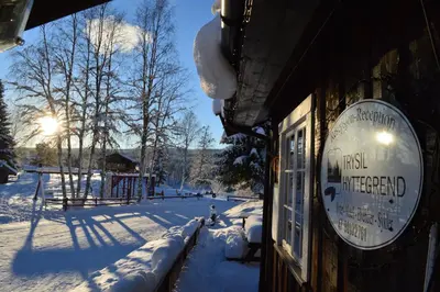 a sign on the side of a building in the snow at Trysil Hyttegrend in Trysil