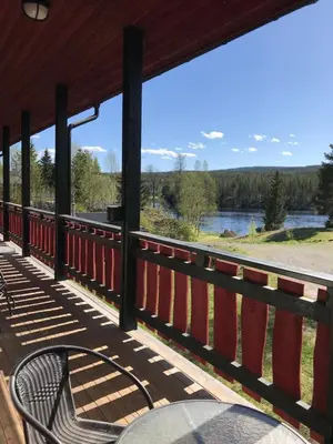 a porch with a table and a view of a river at Trysil Motell & Vandrerhjem in Trysil