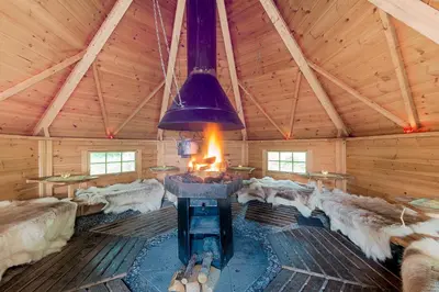 a living room with a fireplace in a log cabin at Trysil Motell & Vandrerhjem in Trysil