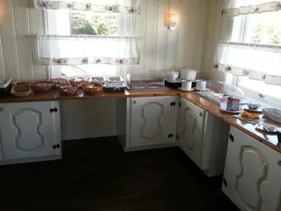 a kitchen with white cabinets and a counter top at Badeland Gjestegård in Raufoss