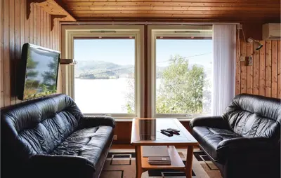 a living room with two leather couches and a table at Lovely Home In Sandvoll With Wifi in Sandvoll