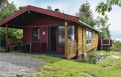 a small cabin with a deck and a table at Lovely Home In Sandvoll With Wifi in Sandvoll