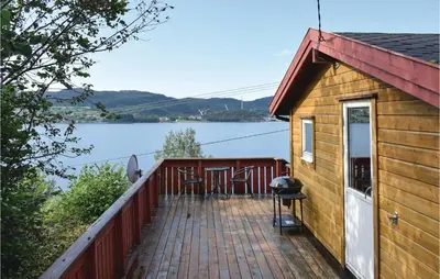 a house with a deck with a grill at Lovely Home In Sandvoll With Wifi in Sandvoll