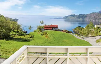 a house on a hill next to a body of water at Awesome Home In Holmefjord in Holmefjord