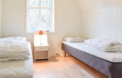 a bedroom with two beds and a window at Awesome Home In Holmefjord in Holmefjord
