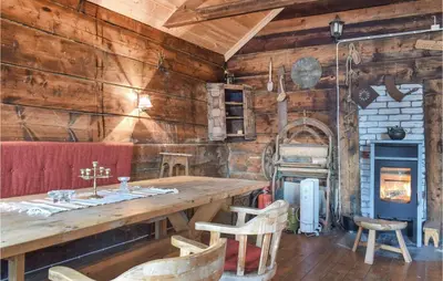 a dining room with a wooden table and a stove at 1 Bedroom Cozy Home In Vallavik in Kaland