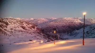 a snow covered mountain with a street light on it at Røldal in Røldal