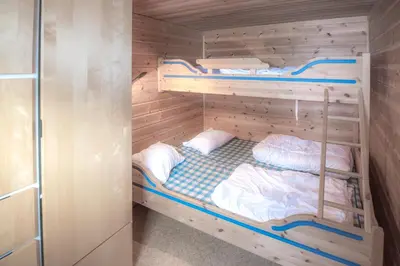 a bedroom with two bunk beds in a room at Fjelltun 12-Sengs in Trysil