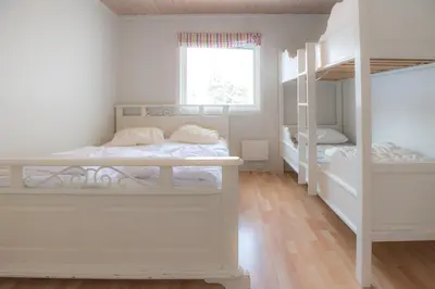 a bedroom with two bunk beds and a window at Fjelltun 12-Sengs in Trysil