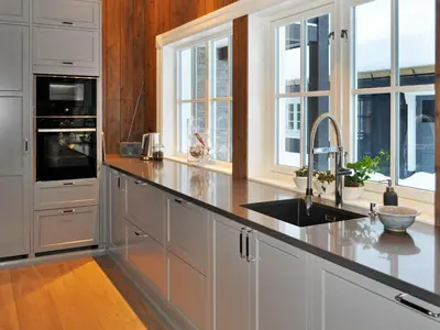 a kitchen with white cabinets and a sink and windows at 12 person holiday home in Fåvang in Favang