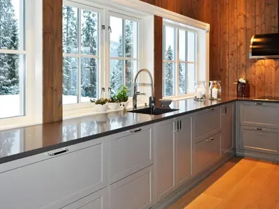 a kitchen with white cabinets and a sink and windows at 12 person holiday home in Fåvang in Favang