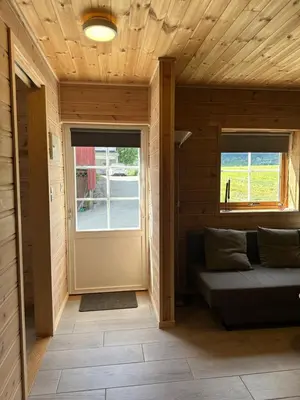 a room with a door and a couch and a window at Haugo Utleige Lodge in Vossevangen