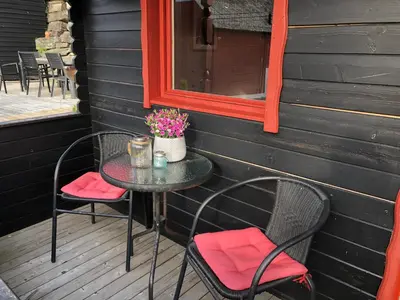 a table and chairs on a porch with a mirror at Haugo Utleige Lodge in Vossevangen