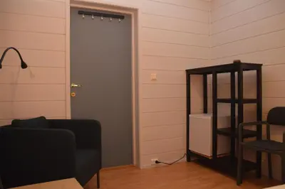 a room with a door and a chair and a shelf at Haugo Utleige Lodge in Vossevangen