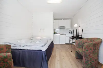 a small room with a bed and two chairs at Midttun Motell & Camping AS in Bergen