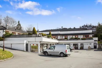 a van parked in a parking lot in front of a building at Midttun Motell & Camping AS in Bergen