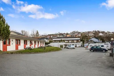 a parking lot with cars parked in front of a building at Midttun Motell & Camping AS in Bergen