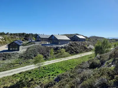 a group of houses on a hill with a road at Atlanterhavsveien Rorbuer in Averoy