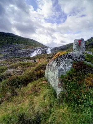 a large rock sitting on a hill with a waterfall at Sognevegen 2242 in Haugsvær
