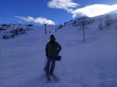 a man is standing on skis in the snow at Sognevegen 2242 in Haugsvær