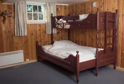 two bunk beds in a room with wooden walls at Rondaplassen in Kvam