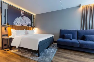a hotel room with a bed and a couch at Radisson Blu Royal Garden Hotel, Trondheim in Trondheim