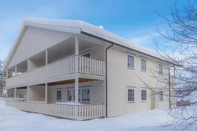 a white house with snow on the ground at Fjelltun 8-sengs in Trysil