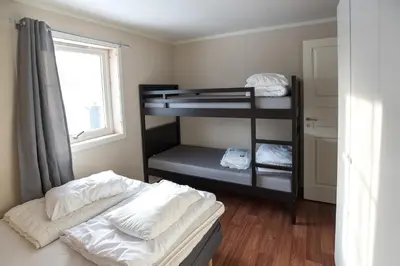 a room with two bunk beds and a window at Fjelltun 8-sengs in Trysil