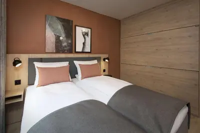 a bedroom with a large white bed with two pillows at Scandic Kokstad in Bergen