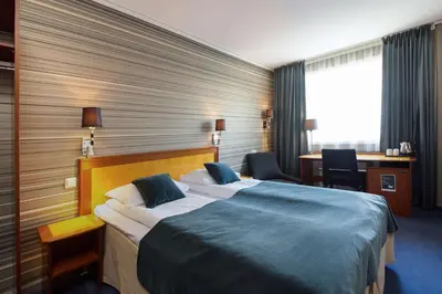 a hotel room with a large bed and a desk at Scandic Bergen City in Bergen
