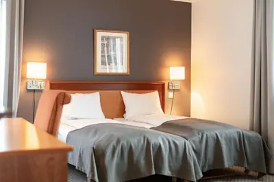 a bedroom with a bed with two lights on it at Scandic Bergen City in Bergen