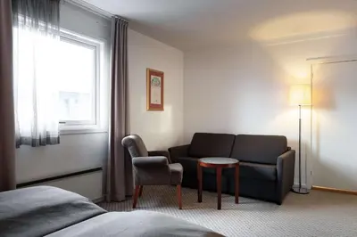 a hotel room with a couch and a table and a window at Scandic Bergen City in Bergen