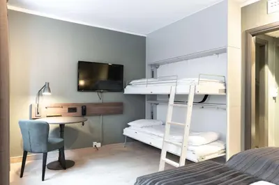 a bedroom with bunk beds and a desk and a bed at Scandic Bergen City in Bergen