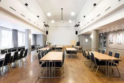 a classroom with tables and chairs in a room at Scandic Bergen City in Bergen
