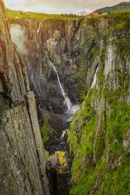 a waterfall on the side of a rocky cliff at Ingrids Apartments in Eidfjord