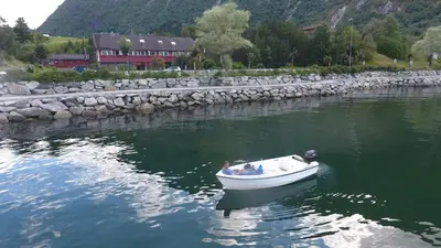a man in a boat in the water at Ingrids Apartments in Eidfjord
