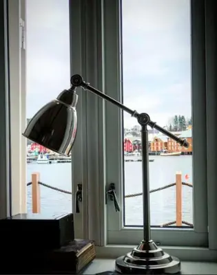 a lamp sitting on a table in front of a window at The Boathouse in Råkvåg