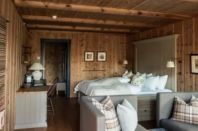 a bedroom with a large bed and a couch at Storfjord Hotel in Skodje