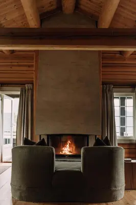 a fireplace in a living room with a couch at Storfjord Hotel in Skodje