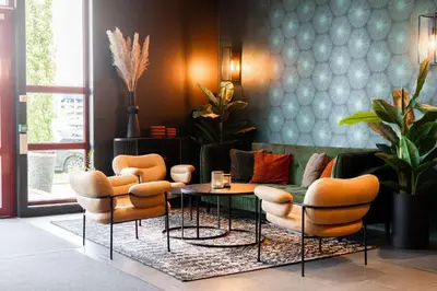 a living room with orange chairs and a couch at Scandic Hell in Hell