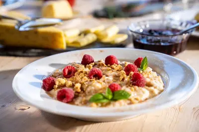 a bowl of oatmeal with berries on a table at Sommerhotellet in Vang I Valdres