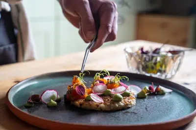 a person cutting a piece of food on a plate at Sommerhotellet in Vang I Valdres