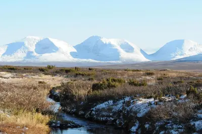a mountain range with snow covered mountains in the distance at Romenstad Hytter in Rendalen