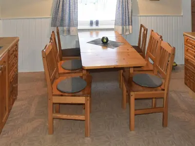 a wooden table with four chairs and a dining room at 8 person holiday home in EIDSVÅG in Eidsvåg