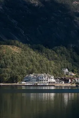 a large house on the shore of a body of water at Vøringfoss Hotel in Eidfjord