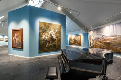 a exhibit in a museum with paintings on the walls at Vøringfoss Hotel in Eidfjord