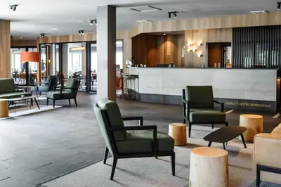 a lobby with chairs and tables and a bar at Vøringfoss Hotel in Eidfjord